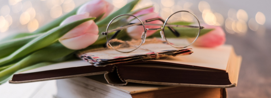 Glasses and pink tulips on a book